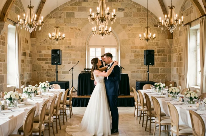 Couple de mariés dansant devant une scène de spectacle dans un château lors de leur réception de mariage
